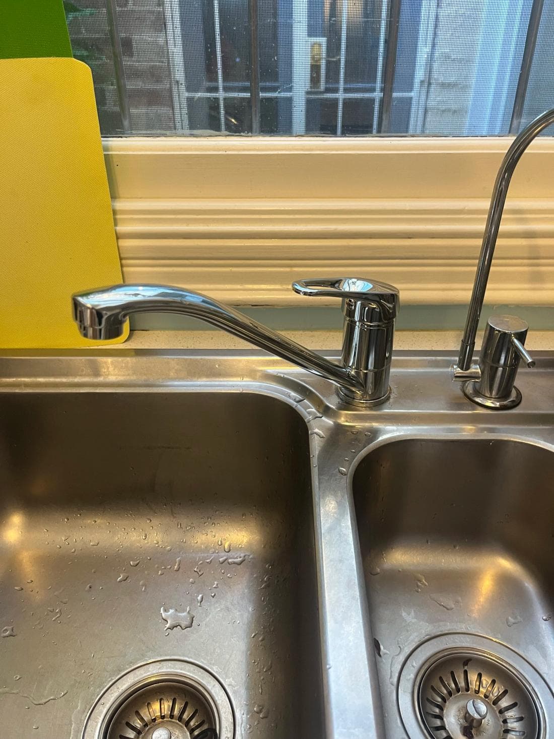 New chrome kitchen mixer tap over a double sink